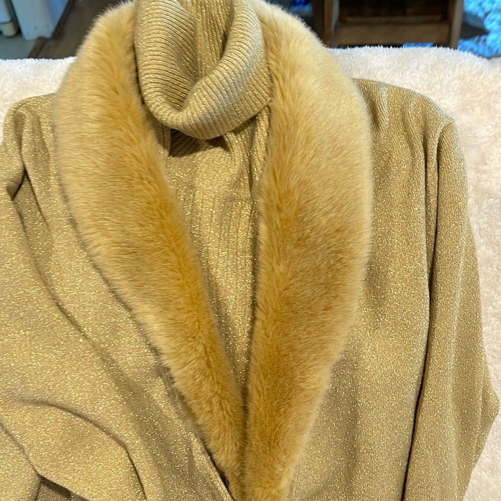 Gold turtleneck with over sweater for fur collar .